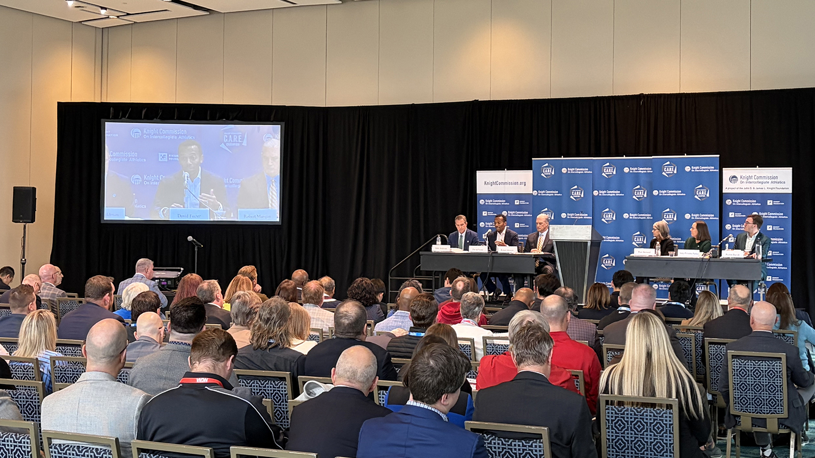 large group of people viewing and listening to a presentation